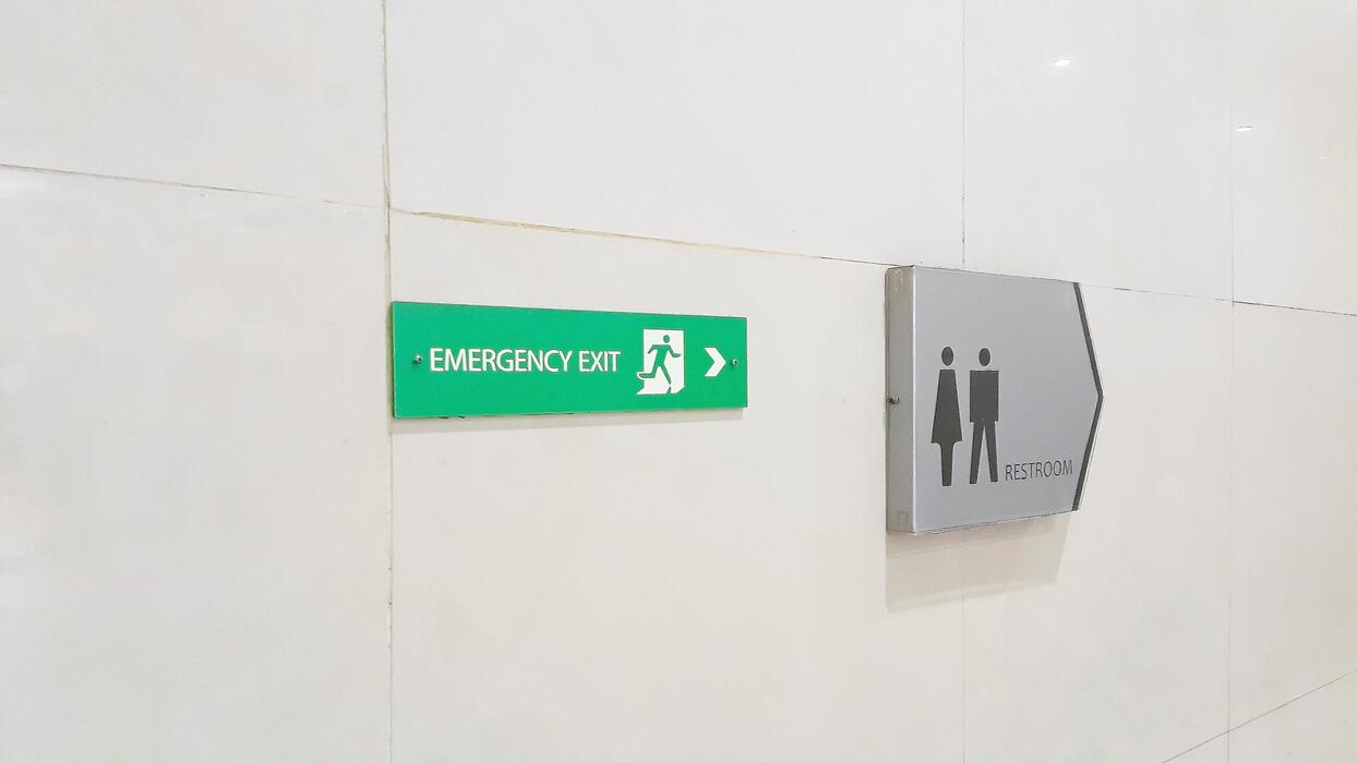 Lit green emergency exit sign in a corridor
